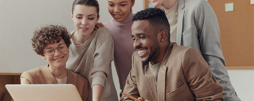 five individuals looking at a laptop computer and smiling